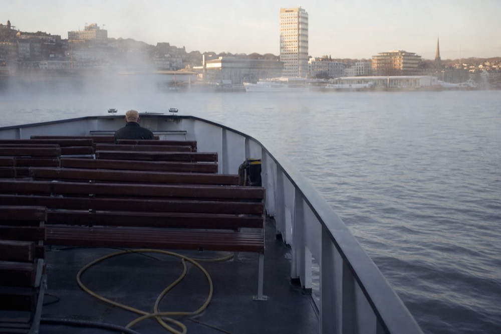A nearly empty tour boat on calm morning water in Charleston Harbor, no text, no logos, no people.