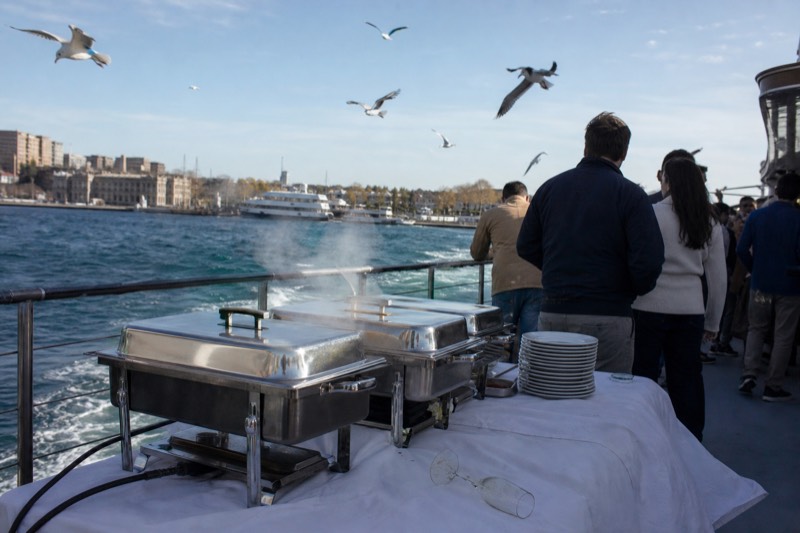 Brunch cruise boat leaving the dock on a clear Charleston morning with chafing dishes steaming on the aft deck